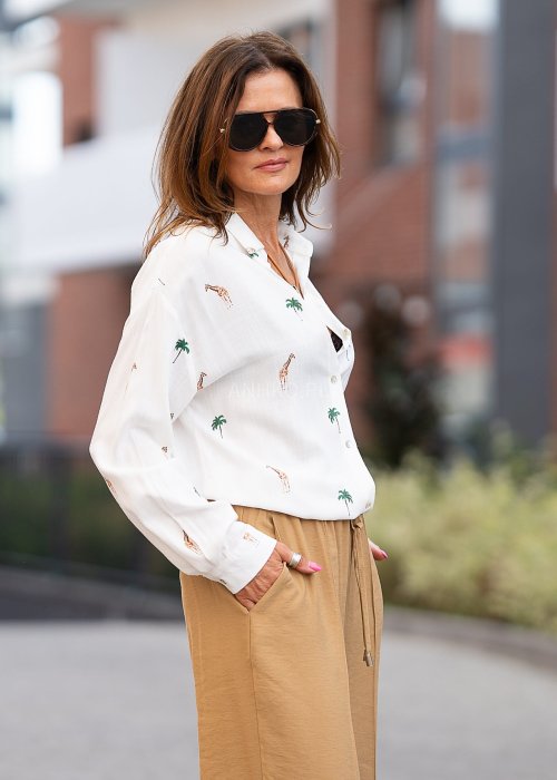 Biała koszula damska z długim rękawem, zapinana na guziki, z nadrukiem żyraf i palm, lekka tkanina idealna na letnie stylizacje