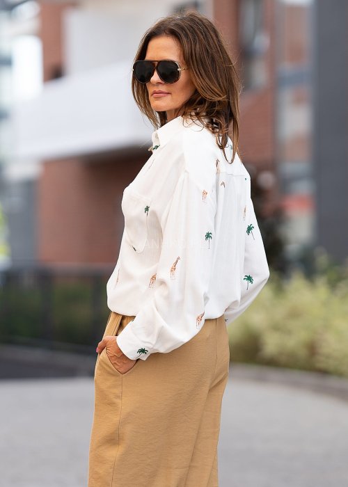Biała koszula damska z długim rękawem, zapinana na guziki, z nadrukiem żyraf i palm, lekka tkanina idealna na letnie stylizacje