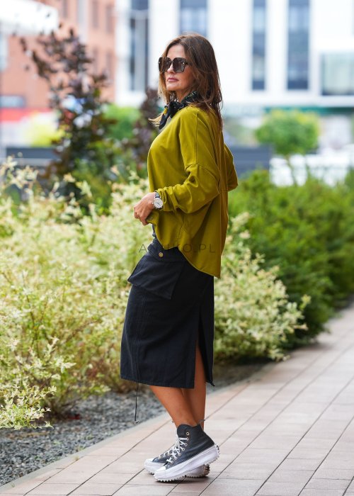 Oliwkowa bawełniana bluza damska Nora o bardzo luźnym kroju oversize z wydłużonym tyłem i dekoracyjną naszywką przy dolnej krawędzi.