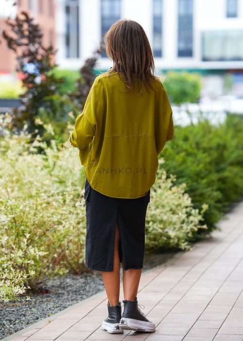 Oliwkowa bawełniana bluza damska Nora o bardzo luźnym kroju oversize z wydłużonym tyłem i dekoracyjną naszywką przy dolnej krawędzi.
