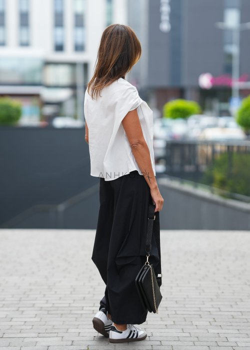 "Biała bluzka damska z krótkim rękawem, asymetryczny dekolt, lekki materiał, minimalistyczna letnia stylizacja"