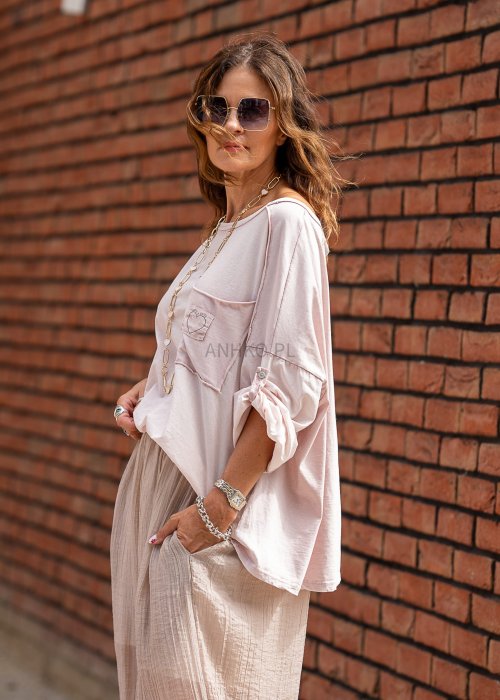 Pudroworóżowa bluzka oversize Blush Amore z szerokim dekoltem i regulowanymi rękawami, pokazana od tyłu w swobodnej stylizacji.