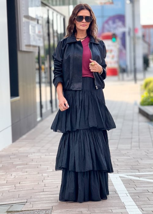 Czarna krótka kurtka damska z długim rękawem i kołnierzem, wykonana ze skóry ekologicznej, styl minimalistyczny