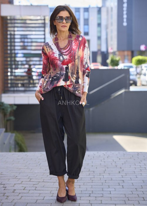 Czarne spodnie damskie RelaxFit z elastycznym pasem i podwiniętymi nogawkami, stylizowane z luźną bluzką i srebrnymi szpilkami w miejskim looku.