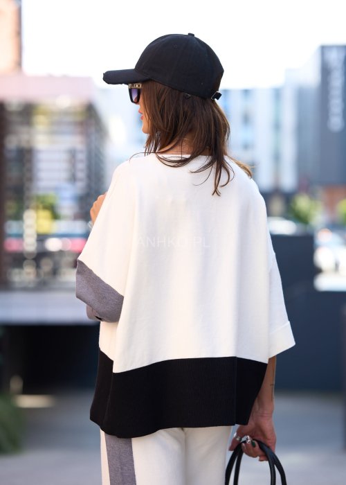 Damski komplet w stylu casual – oversizowa bluzka z szerokimi rękawami w kolorze biało–szaro–czarnym, ozdobiona broszkami przy mankietach, zestawiona z dopasowanymi spodniami w tej samej kolorystyce