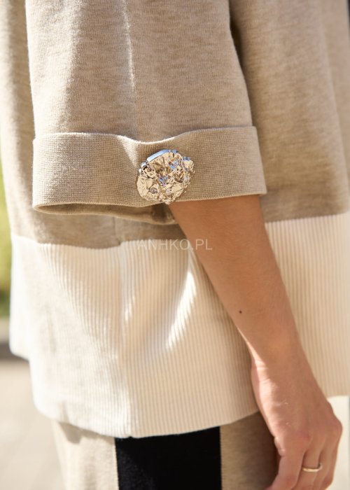 Damski beżowy komplet dresowy – luźna bluza z szerokimi rękawami i kontrastowymi czarnymi wstawkami, zestawiona ze spodniami z szerokimi nogawkami, wykończonymi białymi panelami