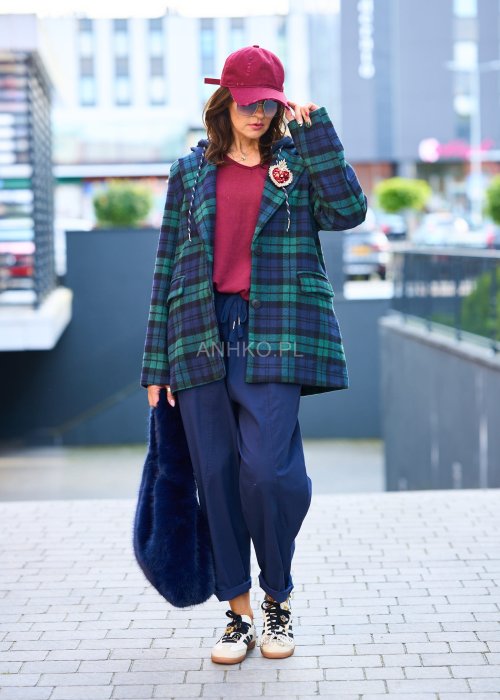 Granatowe spodnie damskie o luźnym kroju boyfriend z elastycznym pasem i troczkiem, pokazane w codziennej stylizacji ze sneakersami. Model ma zwężaną nogawkę, boczne kieszenie i swobodnie układa się na sylwetce.