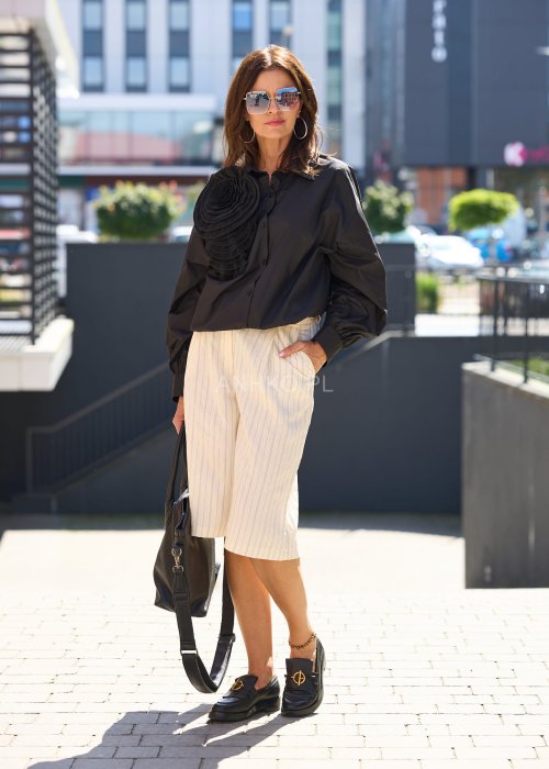 Czarna koszula damska z długim rękawem, ozdobiona dużą plisowaną aplikacją w formie kwiatu, elegancki styl