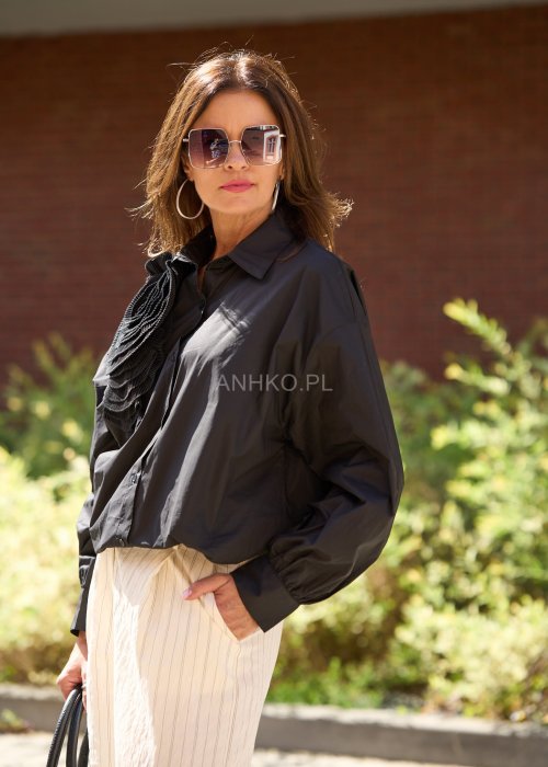 Czarna koszula damska z długim rękawem, ozdobiona dużą plisowaną aplikacją w formie kwiatu, elegancki styl