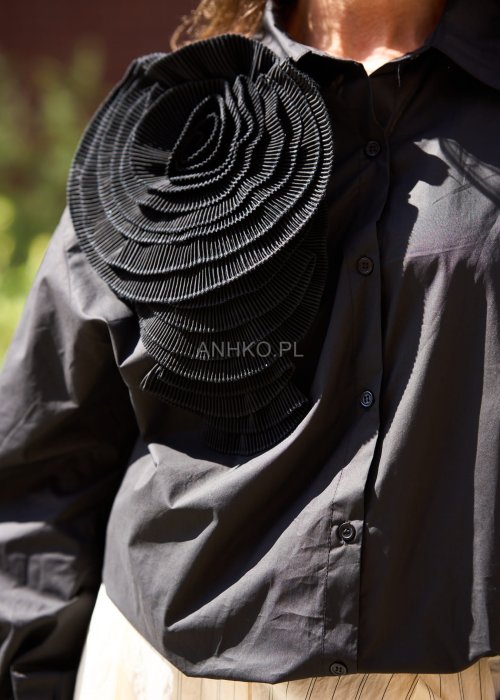 Czarna koszula damska z długim rękawem, ozdobiona dużą plisowaną aplikacją w formie kwiatu, elegancki styl