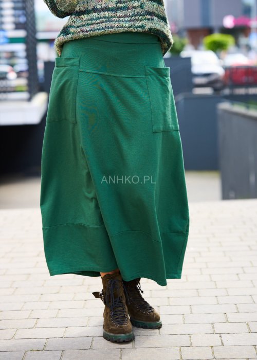 Zielone spódnico-spodnie maxi z dużymi kieszeniami i elastycznym pasem, stylizowane w miejskim looku z luźną górą i botkami.