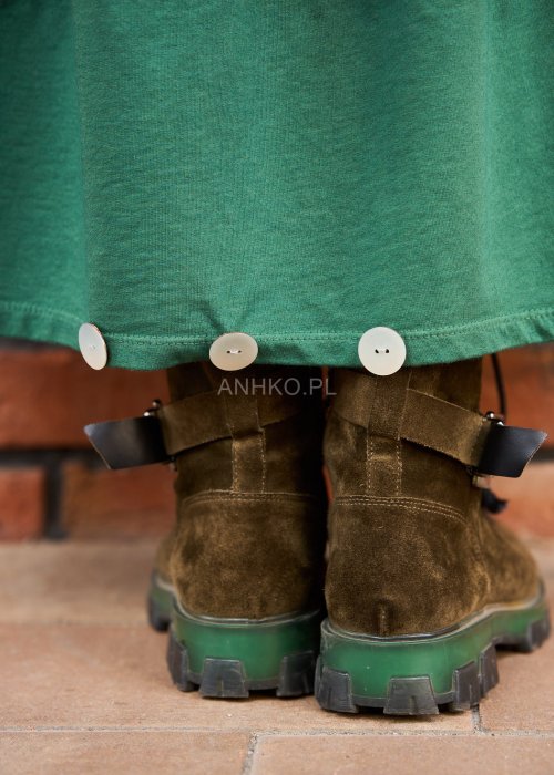 Zielone spódnico-spodnie maxi z dużymi kieszeniami i elastycznym pasem, stylizowane w miejskim looku z luźną górą i botkami.