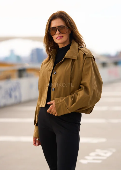 Krótka kurtka khaki damska w stylu trencza z szerokim kołnierzem, pagonami na ramionach, bufiastymi rękawami i zapięciem na guziki.