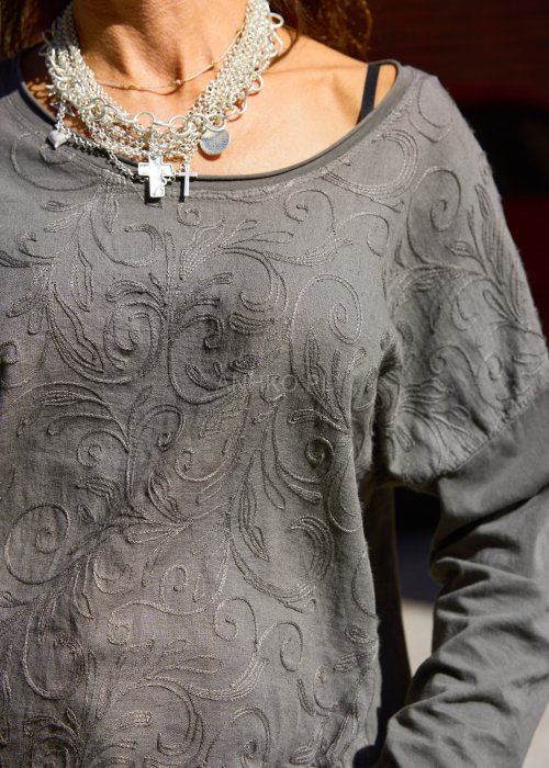 Bluzka w odcieniu szarości o prostym, lekko oversize’owym kroju.