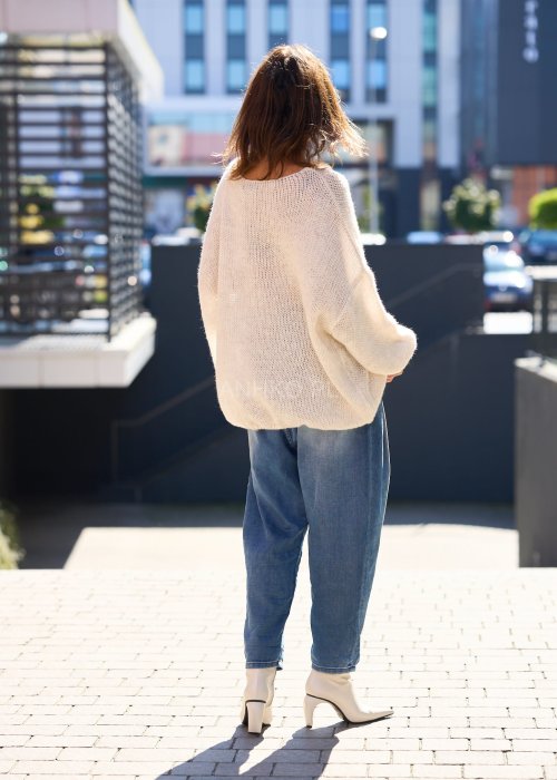 Beżowy sweter o luźnym, oversize’owym kroju, wykonany z przewiewnej, ażurowej dzianiny o grubym splocie.