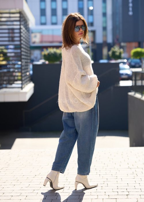 Beżowy sweter o luźnym, oversize’owym kroju, wykonany z przewiewnej, ażurowej dzianiny o grubym splocie.