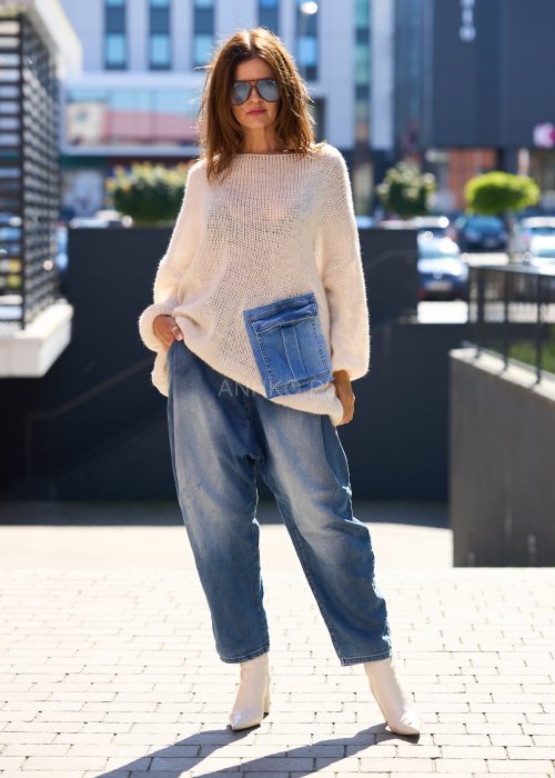 Beżowy sweter o luźnym, oversize’owym kroju, wykonany z przewiewnej, ażurowej dzianiny o grubym splocie.