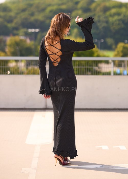 Czarna prążkowana sukienka maxi z długim rękawem i falbaną przy dole, minimalistyczna stylizacja damska