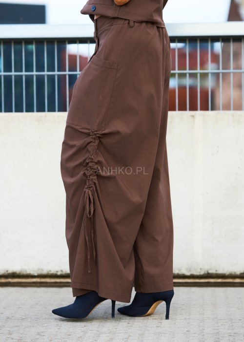 Brązowe spodnie damskie z szeroką nogawką, marszczeniem i wiązaniem po boku, kieszeń z przodu