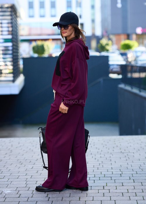 Burgundowy komplet dresowy damski z oversize’ową bluzą z literą M i szerokimi spodniami z elastycznym pasem, stylizacja w miejskim klimacie z czapką z daszkiem.