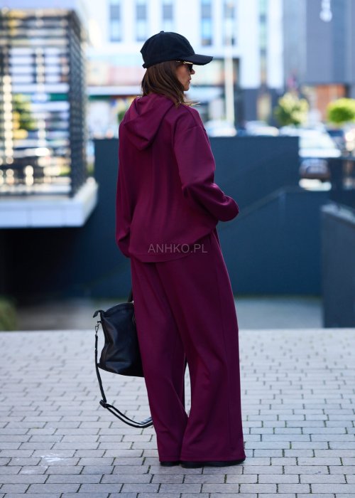 Burgundowy komplet dresowy damski z oversize’ową bluzą z literą M i szerokimi spodniami z elastycznym pasem, stylizacja w miejskim klimacie z czapką z daszkiem.