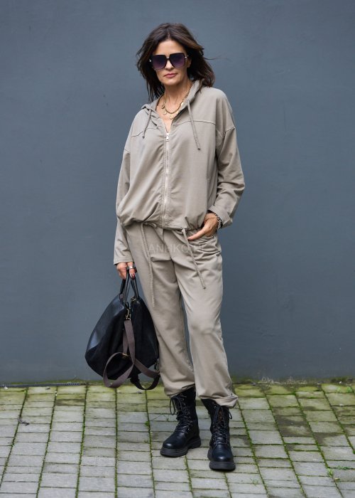 Damski komplet dresowy oversize w kolorze taupe z bluzą na zamek i spodniami z elastycznym pasem, stylizacja miejska z botkami.