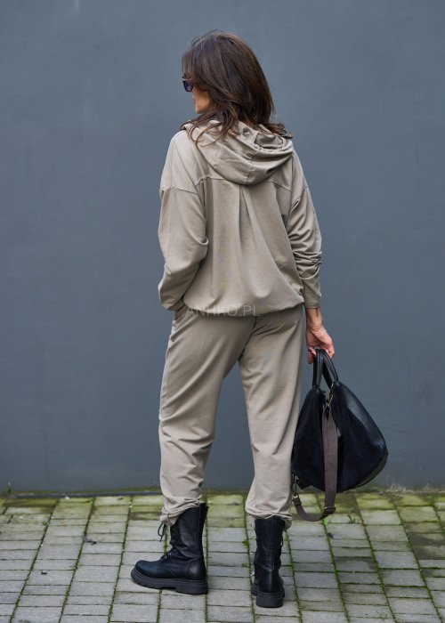 Damski komplet dresowy oversize w kolorze taupe z bluzą na zamek i spodniami z elastycznym pasem, stylizacja miejska z botkami.