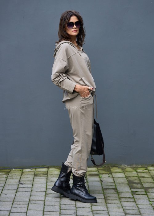 Damski komplet dresowy oversize w kolorze taupe z bluzą na zamek i spodniami z elastycznym pasem, stylizacja miejska z botkami.