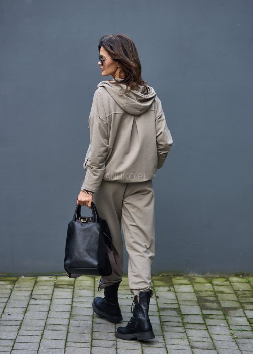 Damski komplet dresowy oversize w kolorze taupe z bluzą na zamek i spodniami z elastycznym pasem, stylizacja miejska z botkami.