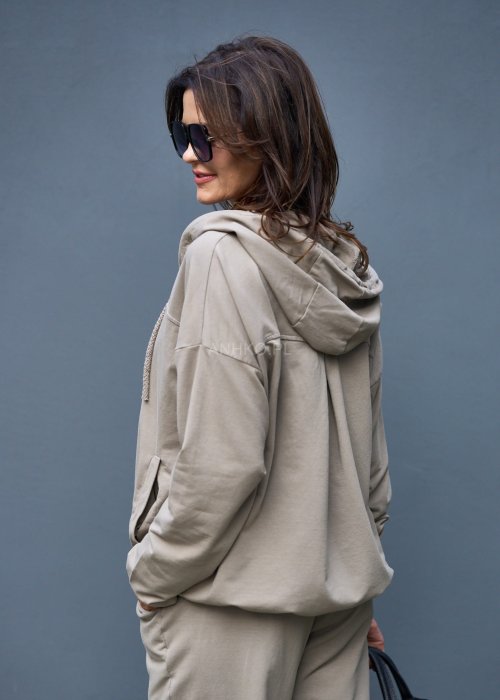 Damski komplet dresowy oversize w kolorze taupe z bluzą na zamek i spodniami z elastycznym pasem, stylizacja miejska z botkami.