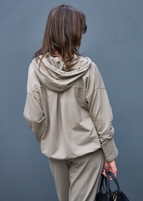 Damski komplet dresowy oversize w kolorze taupe z bluzą na zamek i spodniami z elastycznym pasem, stylizacja miejska z botkami.