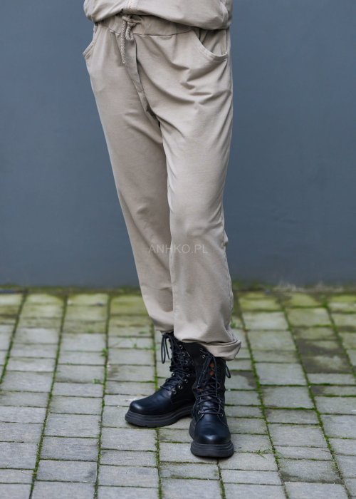 Damski komplet dresowy oversize w kolorze taupe z bluzą na zamek i spodniami z elastycznym pasem, stylizacja miejska z botkami.