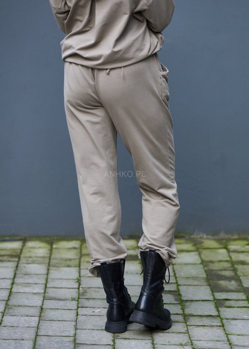 Damski komplet dresowy oversize w kolorze taupe z bluzą na zamek i spodniami z elastycznym pasem, stylizacja miejska z botkami.