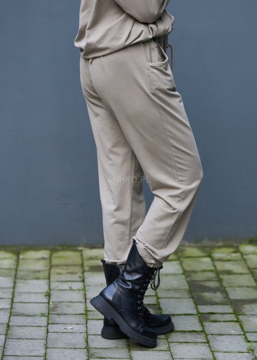 Damski komplet dresowy oversize w kolorze taupe z bluzą na zamek i spodniami z elastycznym pasem, stylizacja miejska z botkami.