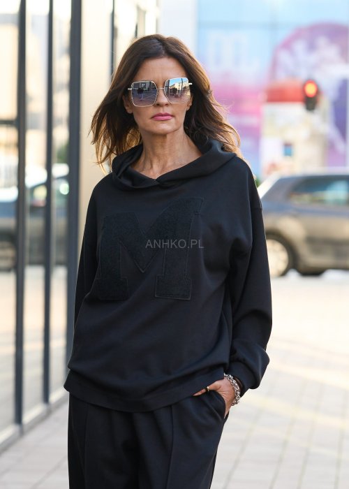 Czarny komplet dresowy damski z oversize’ową bluzą z literą M i szerokimi spodniami z elastycznym pasem, stylizacja w minimalistycznym, miejskim klimacie.