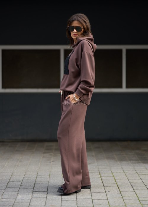 Brązowy komplet dresowy damski z oversize’ową bluzą z literą M i szerokimi spodniami z elastycznym pasem, stylizacja w nowoczesnym miejskim klimacie