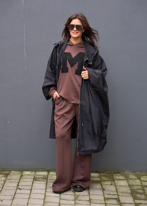Brązowy komplet dresowy damski z oversize’ową bluzą z literą M i szerokimi spodniami z elastycznym pasem, stylizacja w nowoczesnym miejskim klimacie