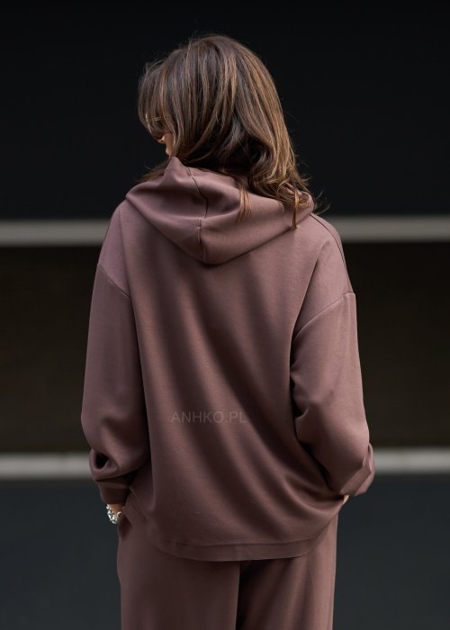 Brązowy komplet dresowy damski z oversize’ową bluzą z literą M i szerokimi spodniami z elastycznym pasem, stylizacja w nowoczesnym miejskim klimacie