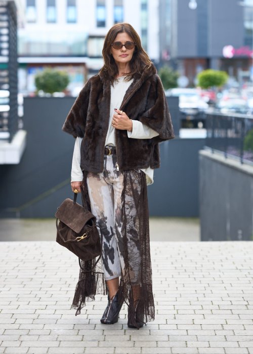 Stylowa damska kamizelka z ciemnobrązowego sztucznego futra z kapturem. Elegancka i ciepła, idealna jako warstwa wierzchnia na chłodniejsze dni.