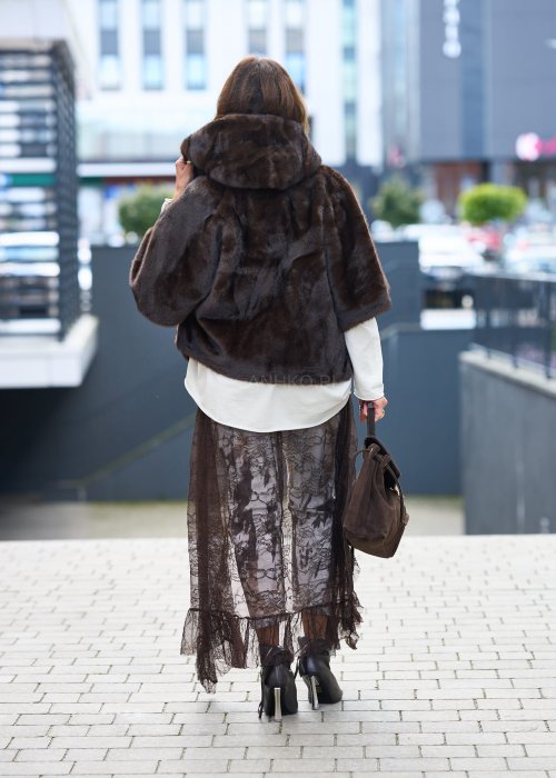 Stylowa damska kamizelka z ciemnobrązowego sztucznego futra z kapturem. Elegancka i ciepła, idealna jako warstwa wierzchnia na chłodniejsze dni.