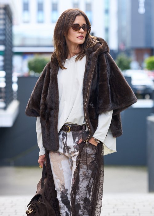 Stylowa damska kamizelka z ciemnobrązowego sztucznego futra z kapturem. Elegancka i ciepła, idealna jako warstwa wierzchnia na chłodniejsze dni.