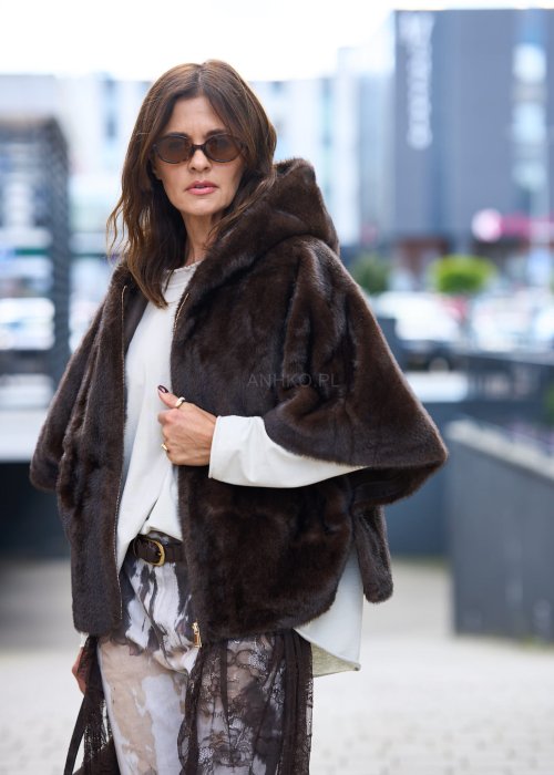 Stylowa damska kamizelka z ciemnobrązowego sztucznego futra z kapturem. Elegancka i ciepła, idealna jako warstwa wierzchnia na chłodniejsze dni.