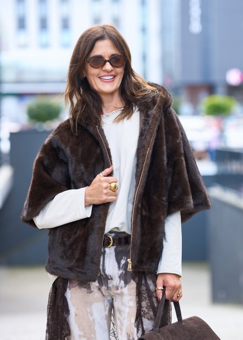 Stylowa damska kamizelka z ciemnobrązowego sztucznego futra z kapturem. Elegancka i ciepła, idealna jako warstwa wierzchnia na chłodniejsze dni.