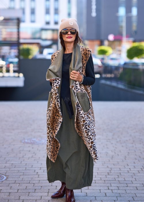 Spódnica maxi w kolorze khaki z elastyczną talią i kieszeniami, o luźnym kroju, zestawiona z wzorzystą bluzką i botkami na słupku w miejskiej stylizacji.