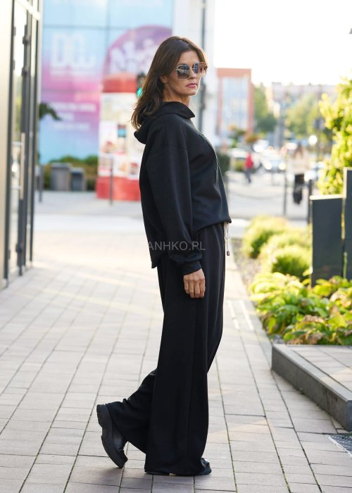 Czarny komplet dresowy damski z oversize’ową bluzą z literą M i szerokimi spodniami z elastycznym pasem, stylizacja w minimalistycznym, miejskim klimacie.