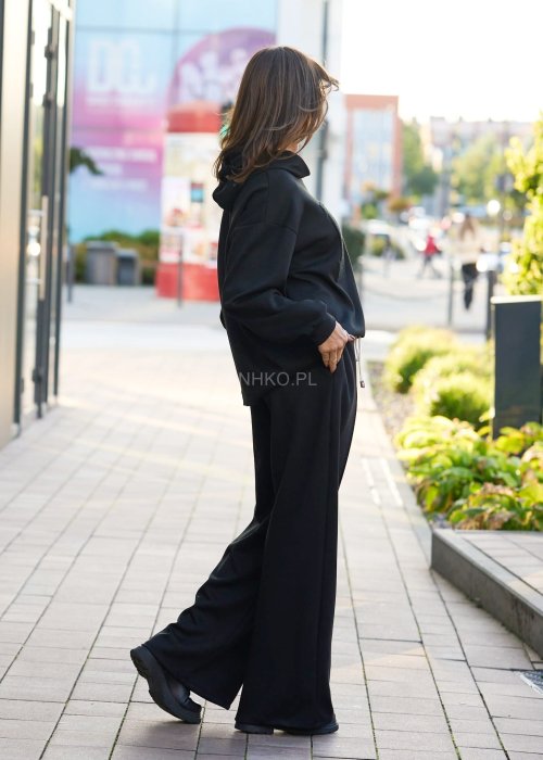 Czarny komplet dresowy damski z oversize’ową bluzą z literą M i szerokimi spodniami z elastycznym pasem, stylizacja w minimalistycznym, miejskim klimacie.