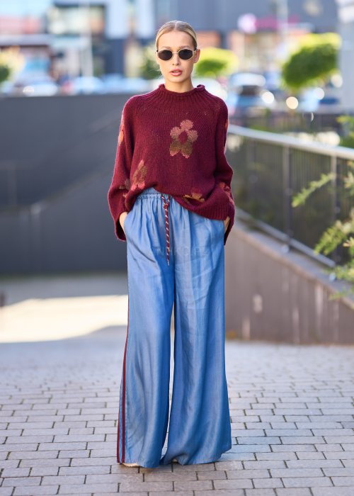 Niebieskie spodnie z lekkiego denimu o szerokich nogawkach, elastycznym pasie i ozdobnych lampasach w kolorze bordo