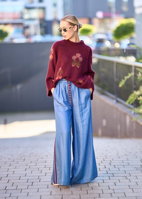 Niebieskie spodnie z lekkiego denimu o szerokich nogawkach, elastycznym pasie i ozdobnych lampasach w kolorze bordo