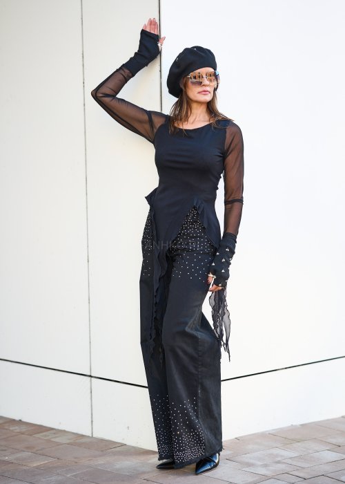 Czarna bluzka z siateczkowymi rękawami i asymetrycznym dołem w stylu boho, idealna do wieczorowych stylizacji