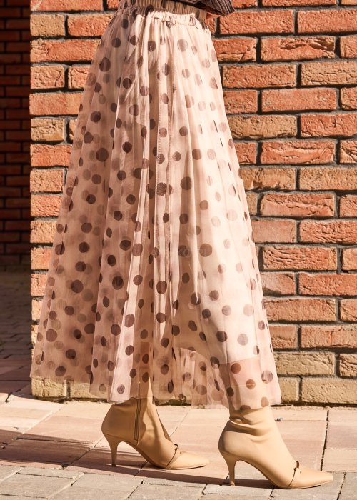 Zwiewna, tiulowa spódnica midi w delikatnym beżowym odcieniu, ozdobiona dużym wzorem w kropki